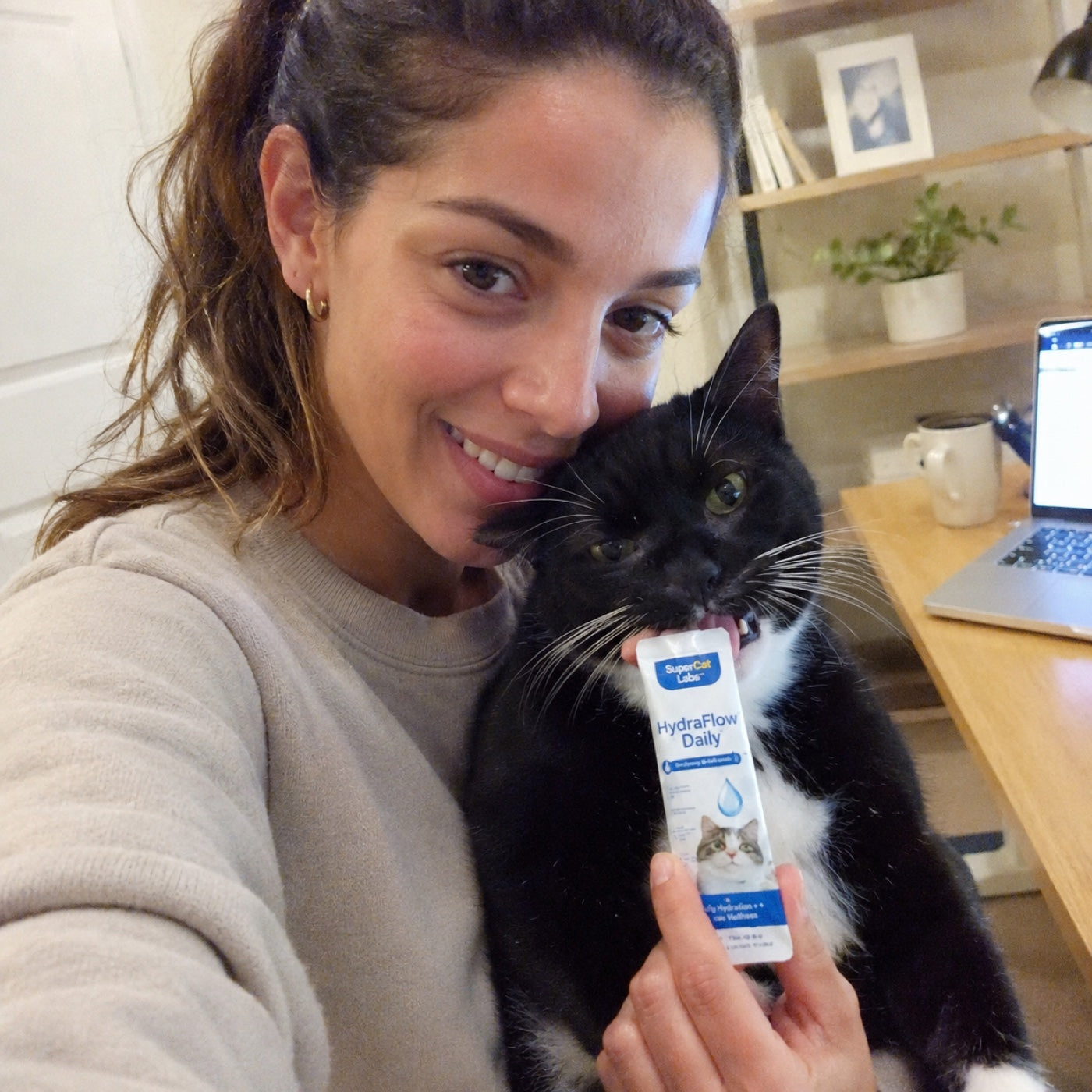 Cat parent with black-and-white cat and SuperCat sachet